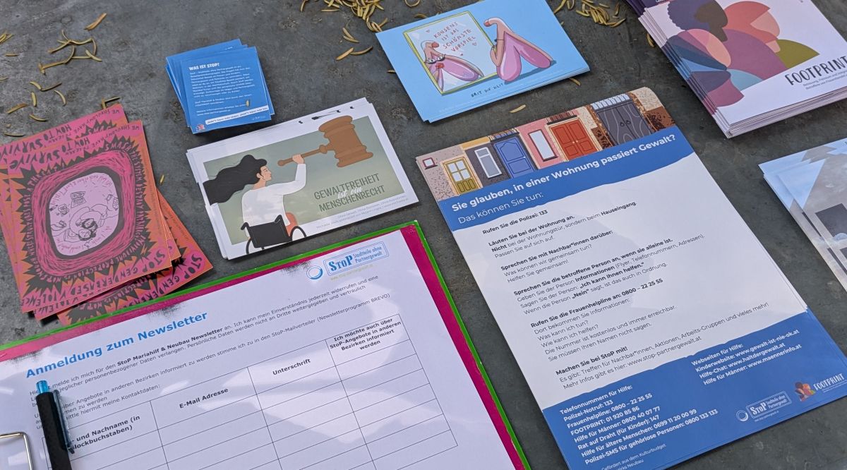 Meine Postkarte liegt schön organisiert mit Informationsmaterialien auf einem Blechuntergrund in einem Wiener Park.