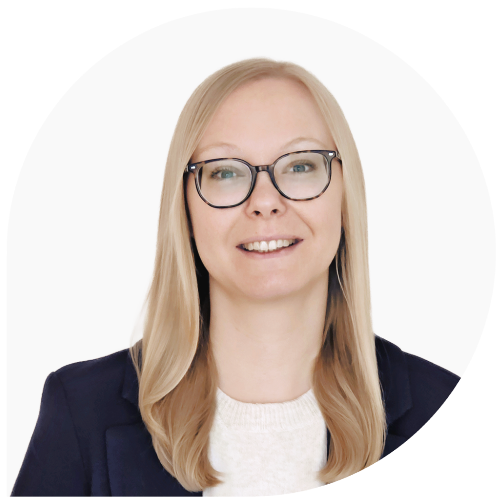 Michaela Joch ist eine weiße Frau Mitte 30, mit blonden 
mittellangen Haaren und blauen Augen. Sie trägt eine Brille, eine weißen Pullover und darüber einen dunkelblauen Blazer. Das
Foto ist vor hellbeigen Wand aufgenommen und Michaela lächelt freundlich.